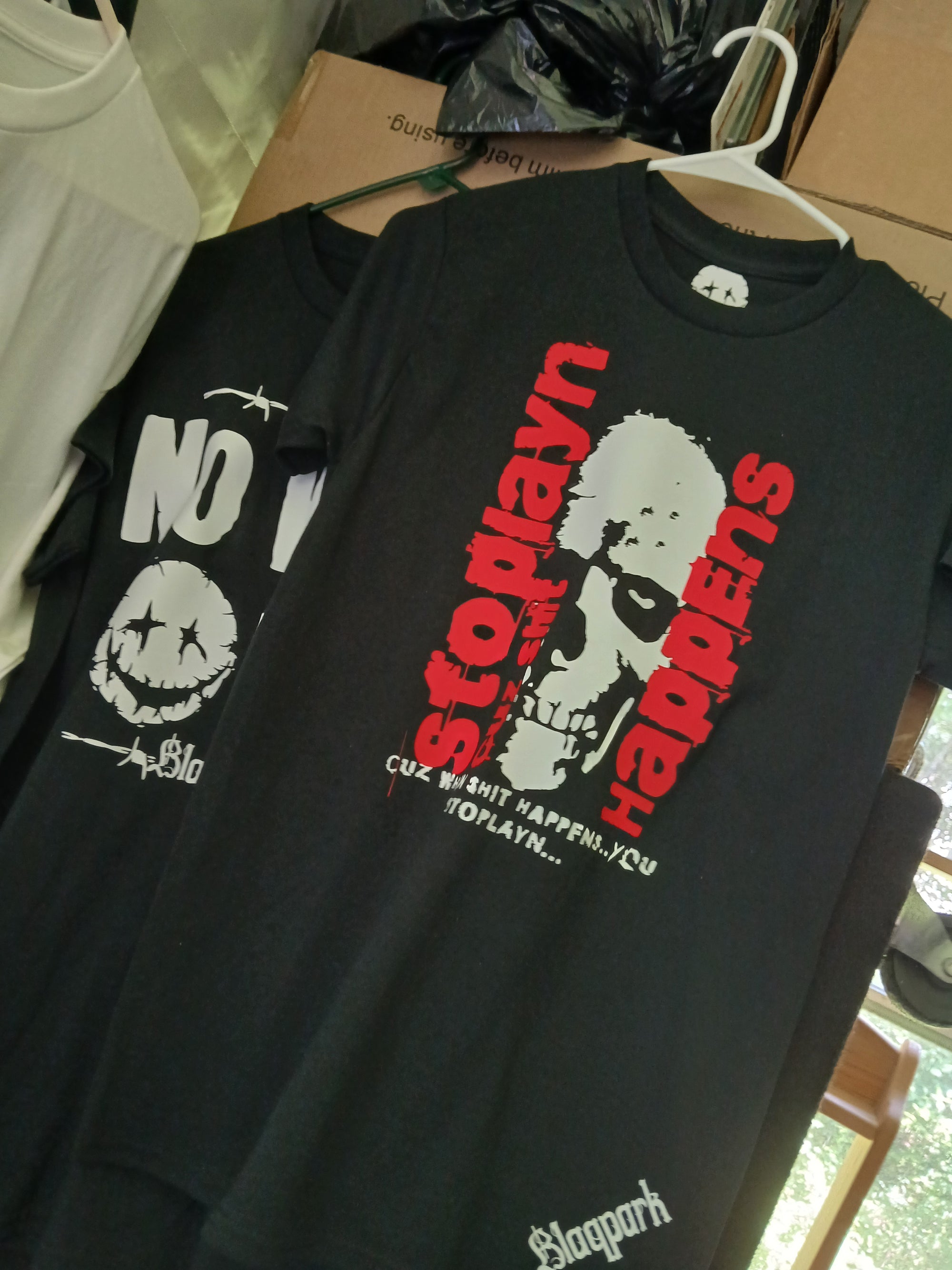 Black t-shirt with graphic design and text on a hanger